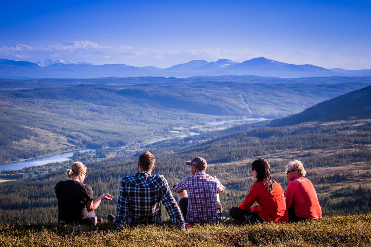 en grupp konferensdeltagare sitter och blickar ut över fjället