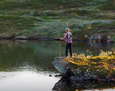 kille som står och fiskar